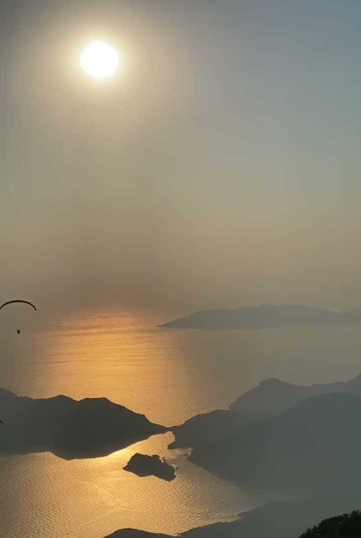 Gün batımında Ölüdeniz adalarının üzerinde süzülen tandem paraşüt