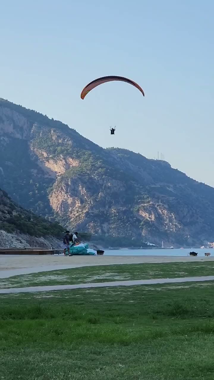Babadağ’ın dik yamaçlarının önünde iniş alanına yaklaşan paraşüt