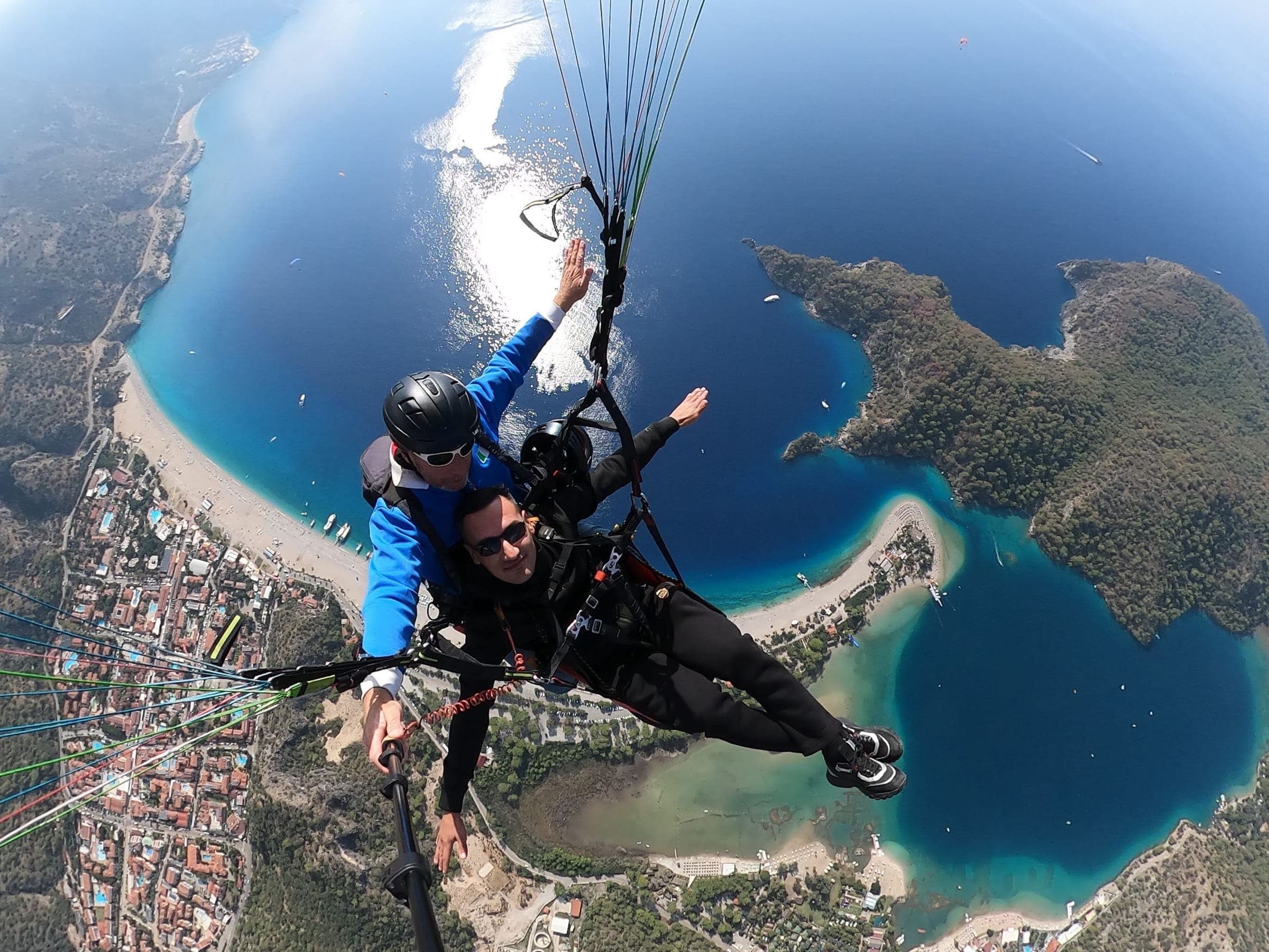 Tandem pilot ve yolcusu, altlarında Ölüdeniz lagünü ve Belcekız plajı